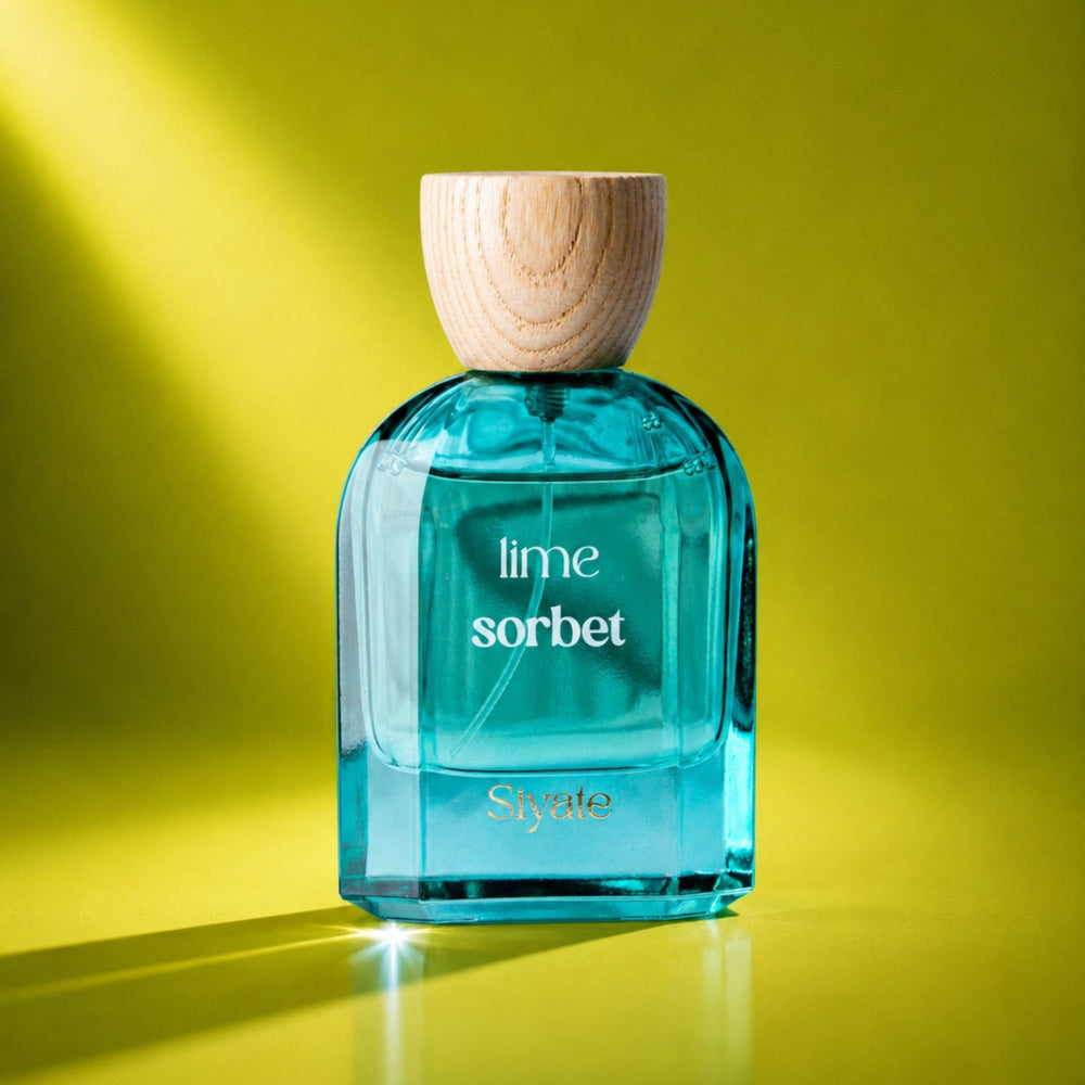 A bottle of Syate Lime Sorbet fragrance with bright turquoise-blue liquid, a light wood cap, and white lettering, set against a vibrant yellow-green background with dramatic diagonal light rays.