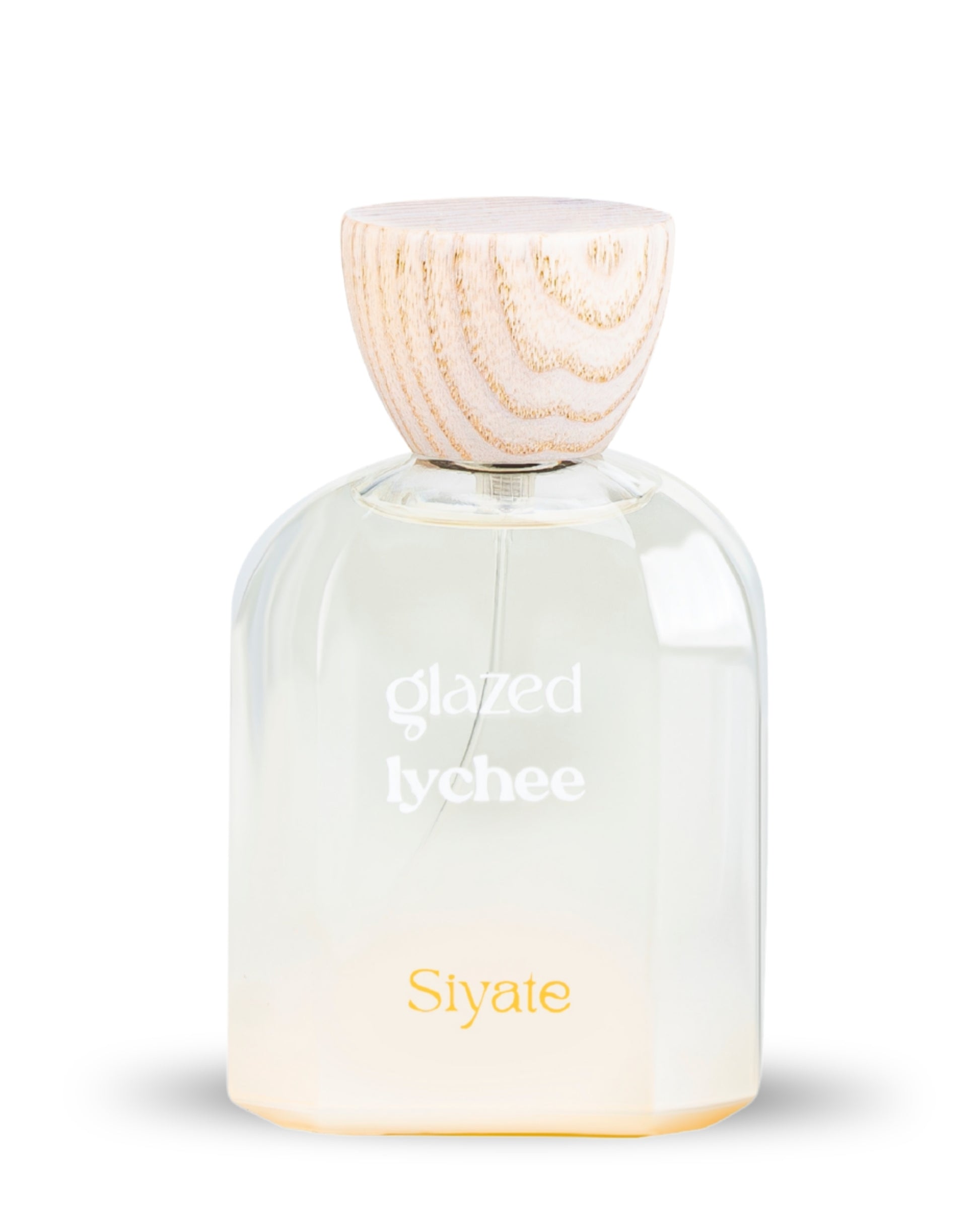 A clear glass perfume bottle with a light wood cap, labeled 'glazed lychee' and 'Siyate', on a white background.