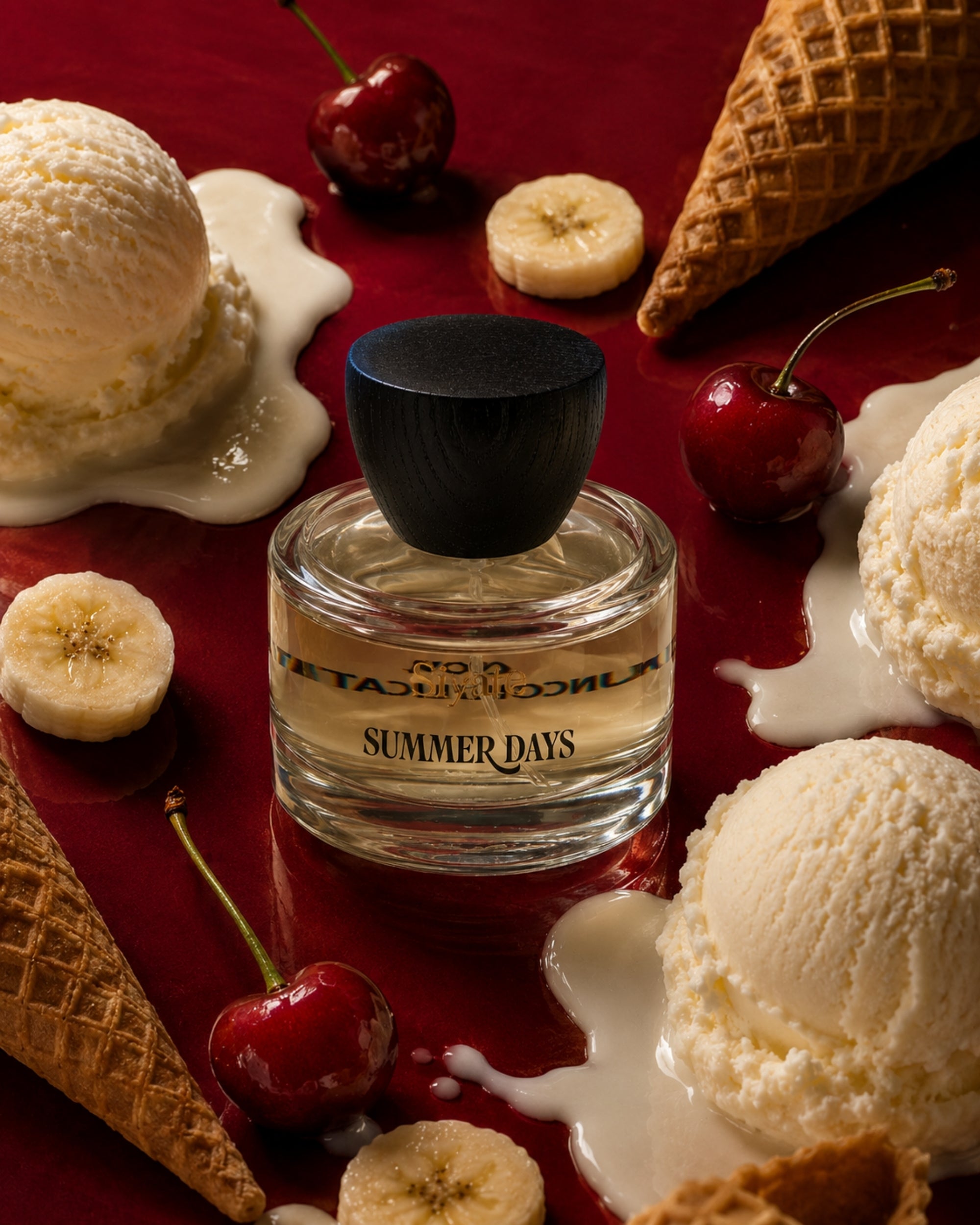 A bottle of siyate 'Summer Days' perfume centered on a rich red background, surrounded by melting vanilla ice cream, cherries, banana slices, and waffle cones.